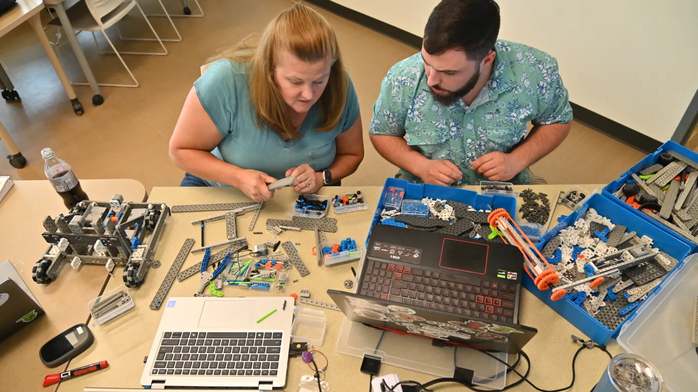 two teachers working on robots