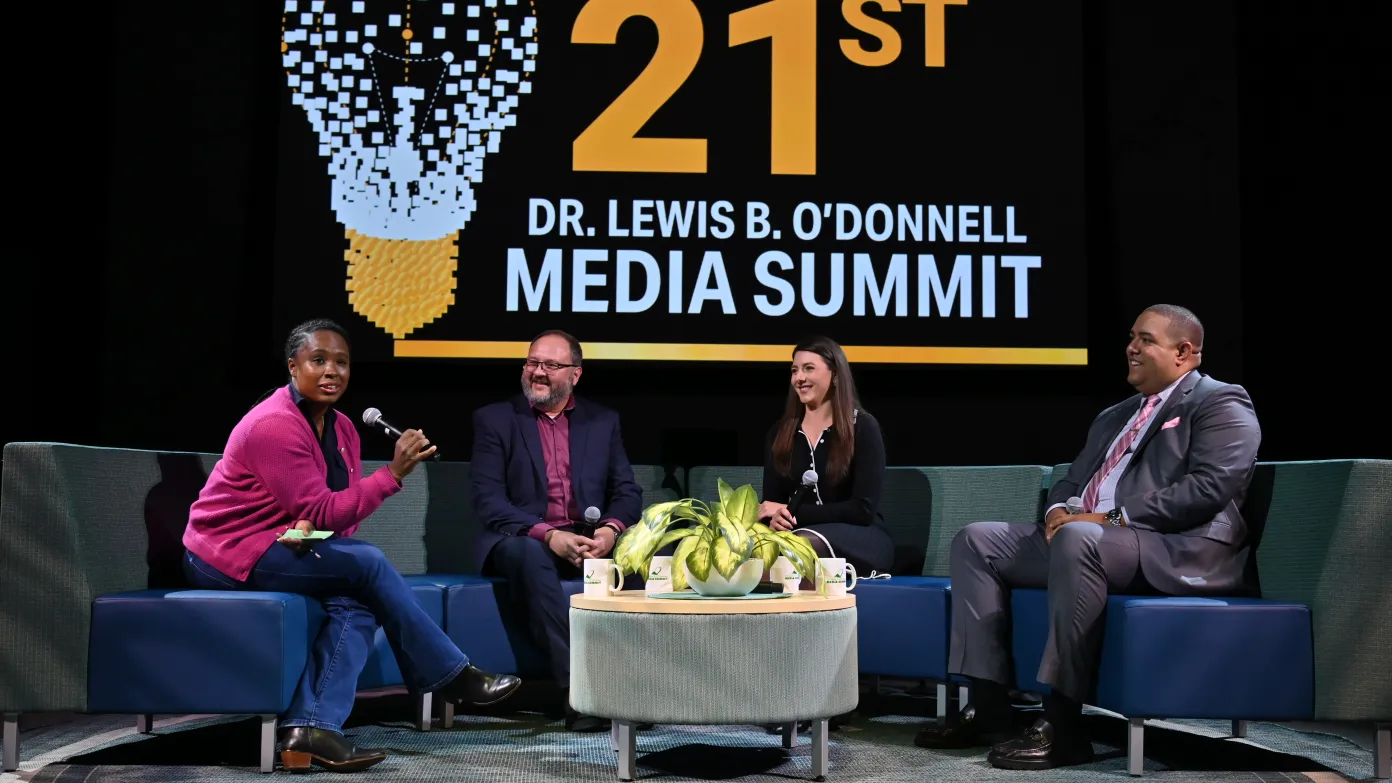 three alumni speaking on stage during the 21st media summit