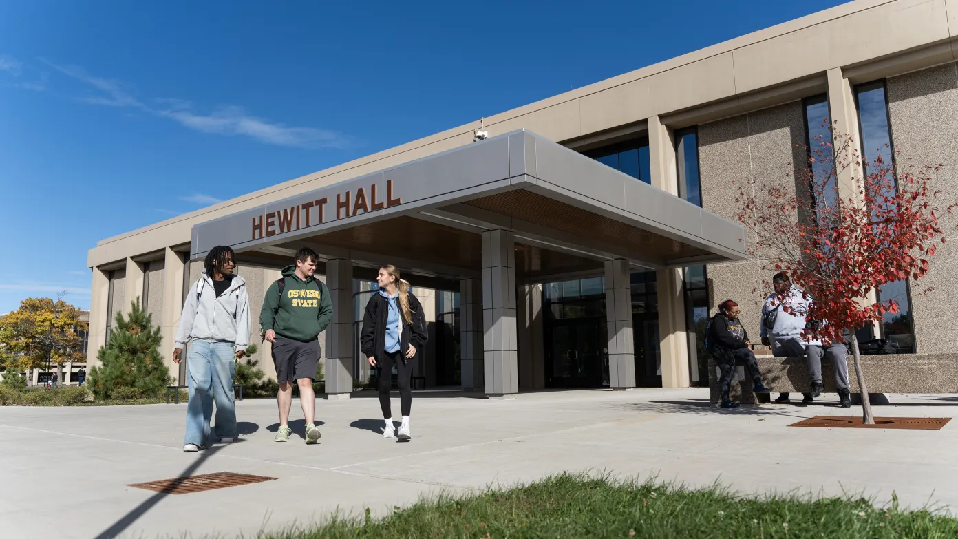 three students walking outside of Hewitt Hall entrance