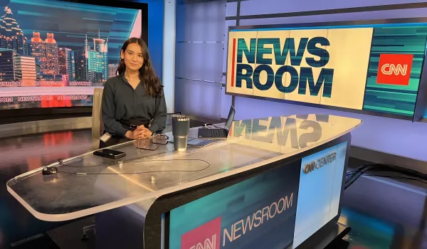 Oswego student Clarissa Karki sits at the CNN news desk at the CNN headquarters in Atlanta.