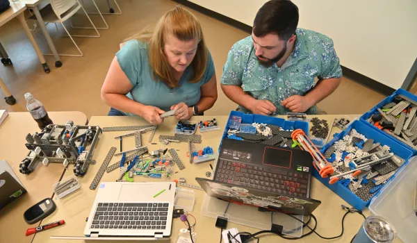 two teachers working on robots