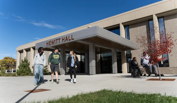 three students walking outside of Hewitt Hall entrance