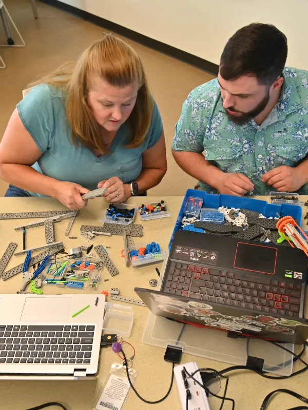 two teachers working on robots