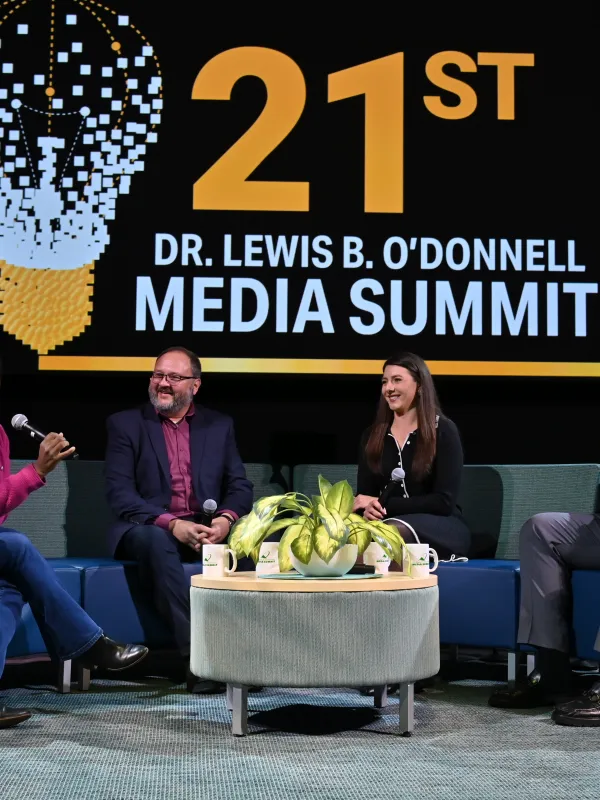 three alumni speaking on stage during the 21st media summit