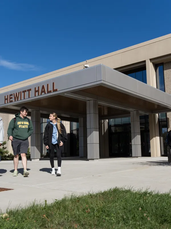 three students walking outside of Hewitt Hall entrance